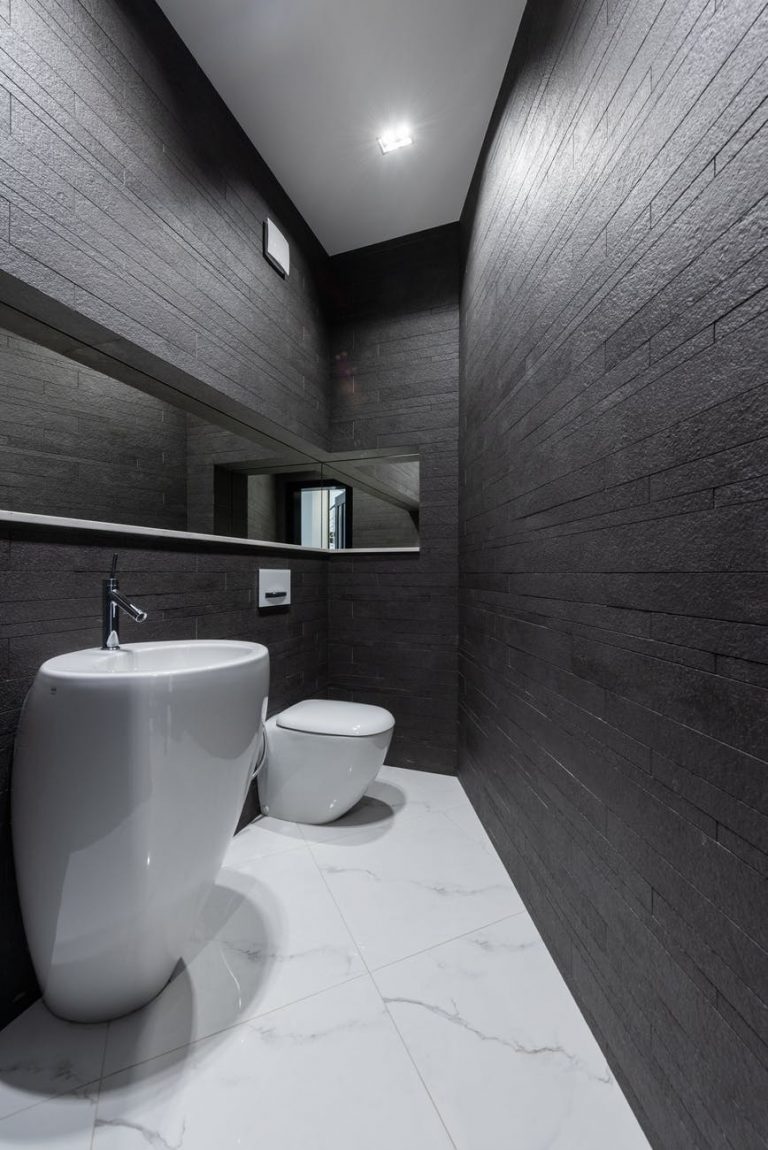 contemporary bathroom interior with dark stone walls and marble styled floor