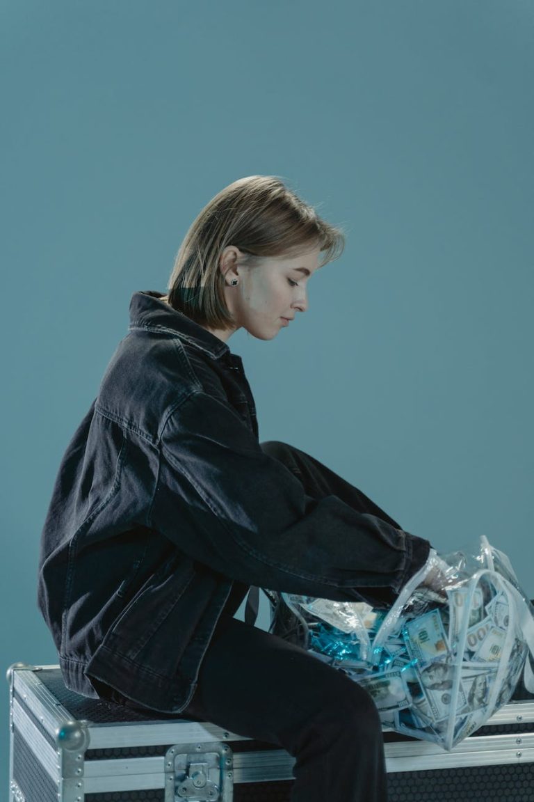woman in black denim jacket counting money inside a plastic bag