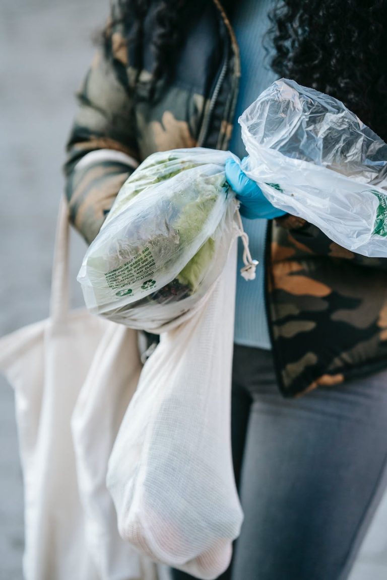 crop unrecognizable woman carrying fresh vegetables on street