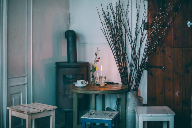 old shabby stools placed around table and iron furnace