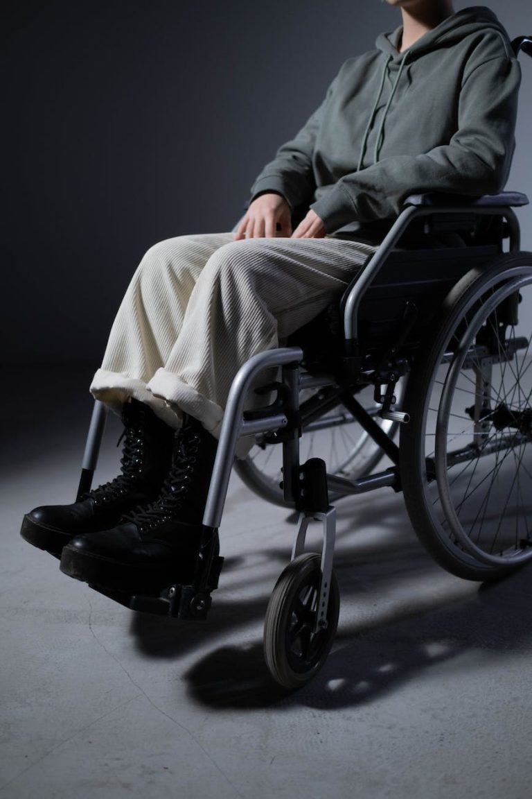 person in gray pants sitting on black wheelchair