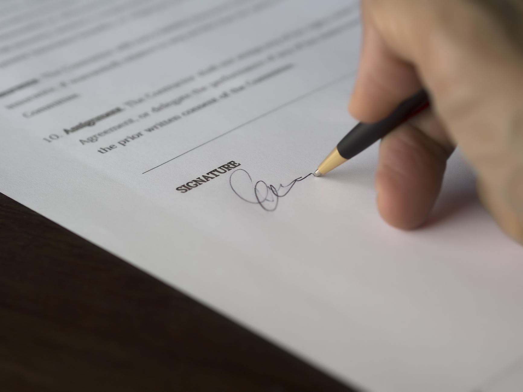 selective focus photography of person signing on paper